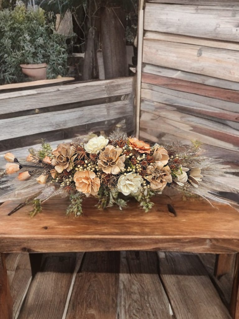 Centro de mesa con flores eternas con fondo de madera