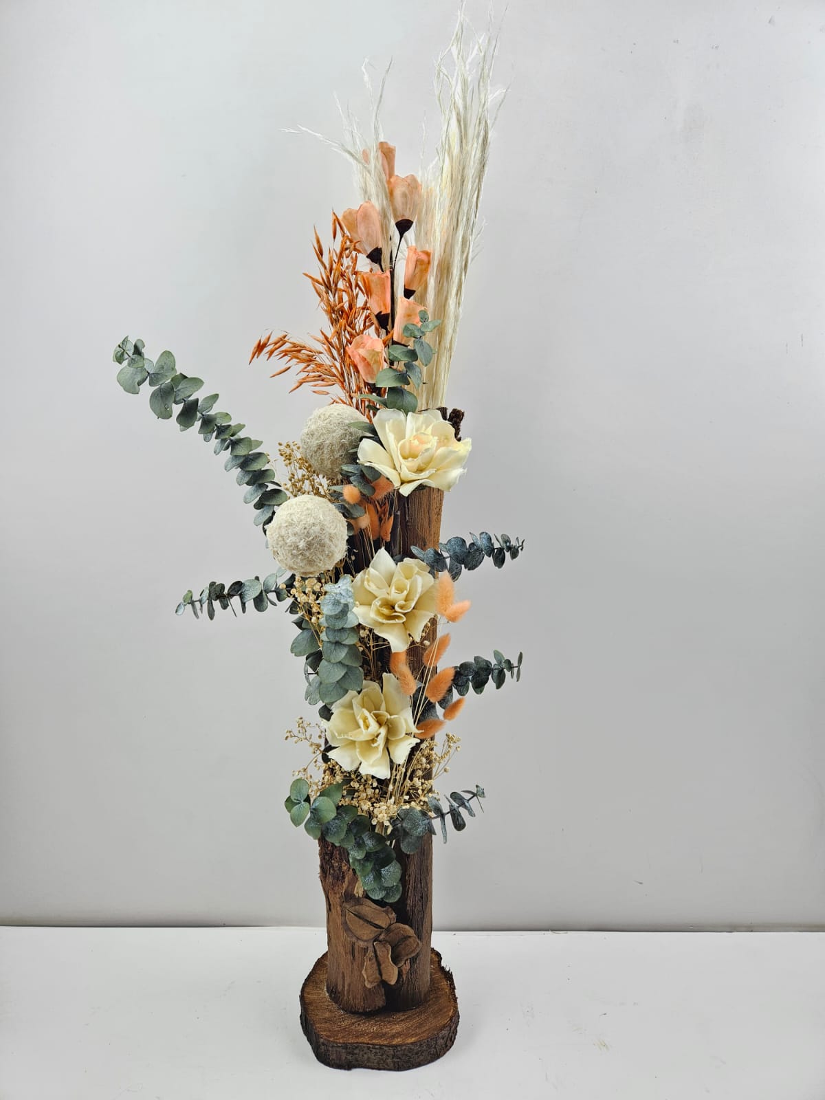 decoracion con flores artificiales en un trozo de madera